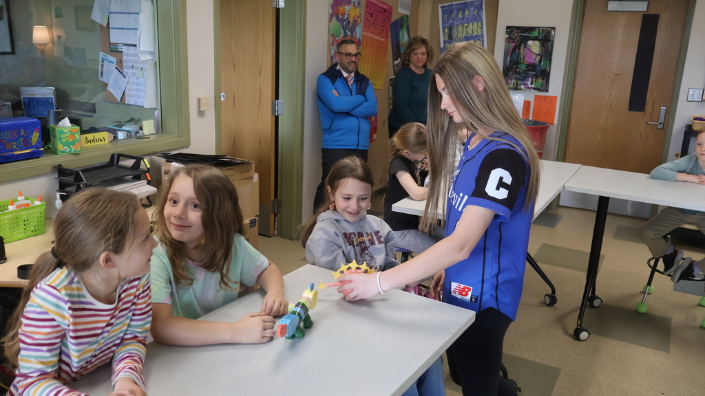 High School Student Delivering Sculpture to Second Grader