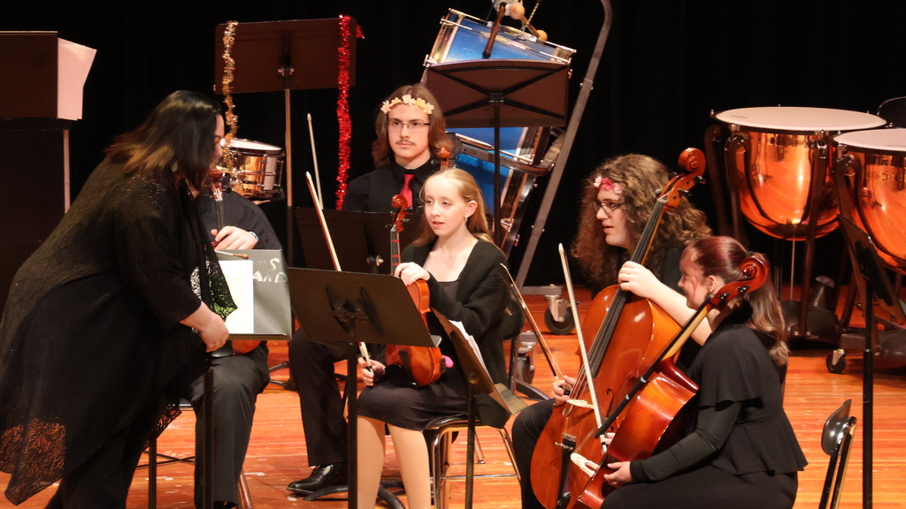 Orchestra Director Jennifer Guhin speaks to her students between pieces
