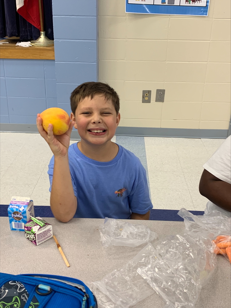 Student holding a peach.