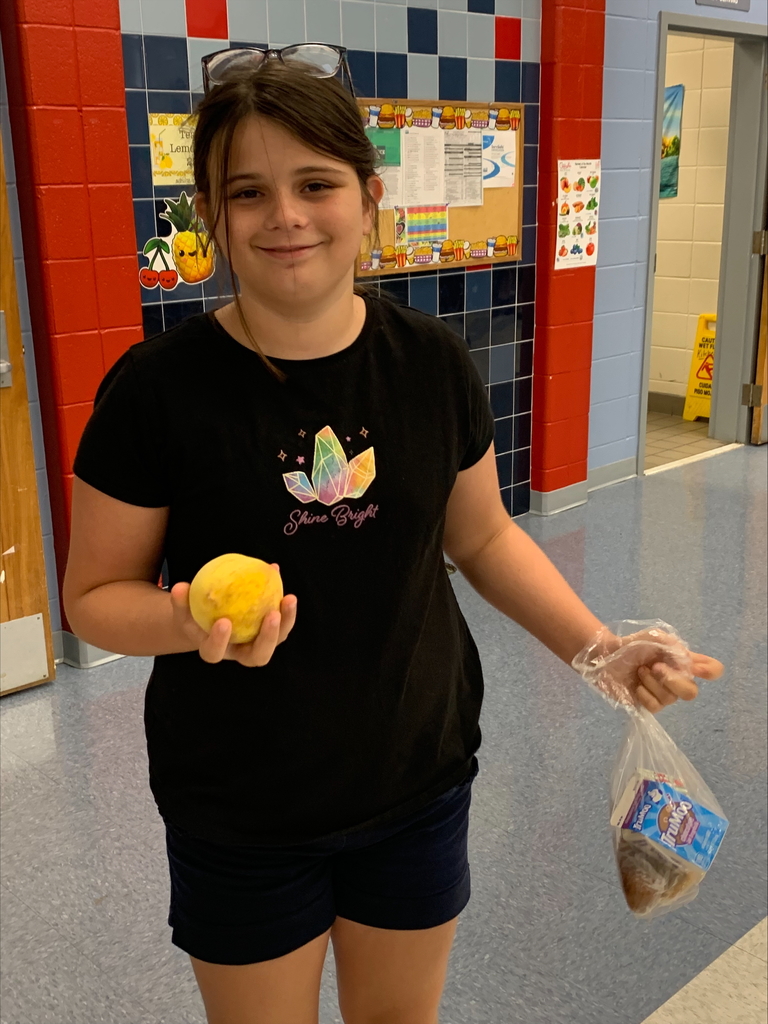 Student holding a peach.