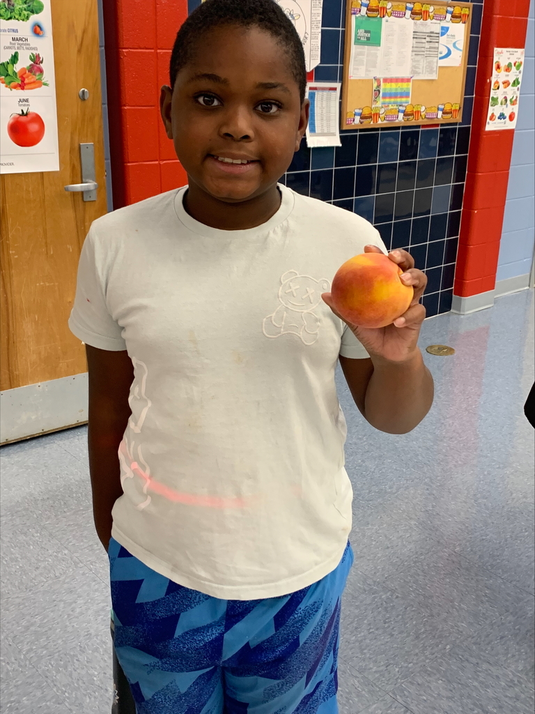 Student holding a peach.