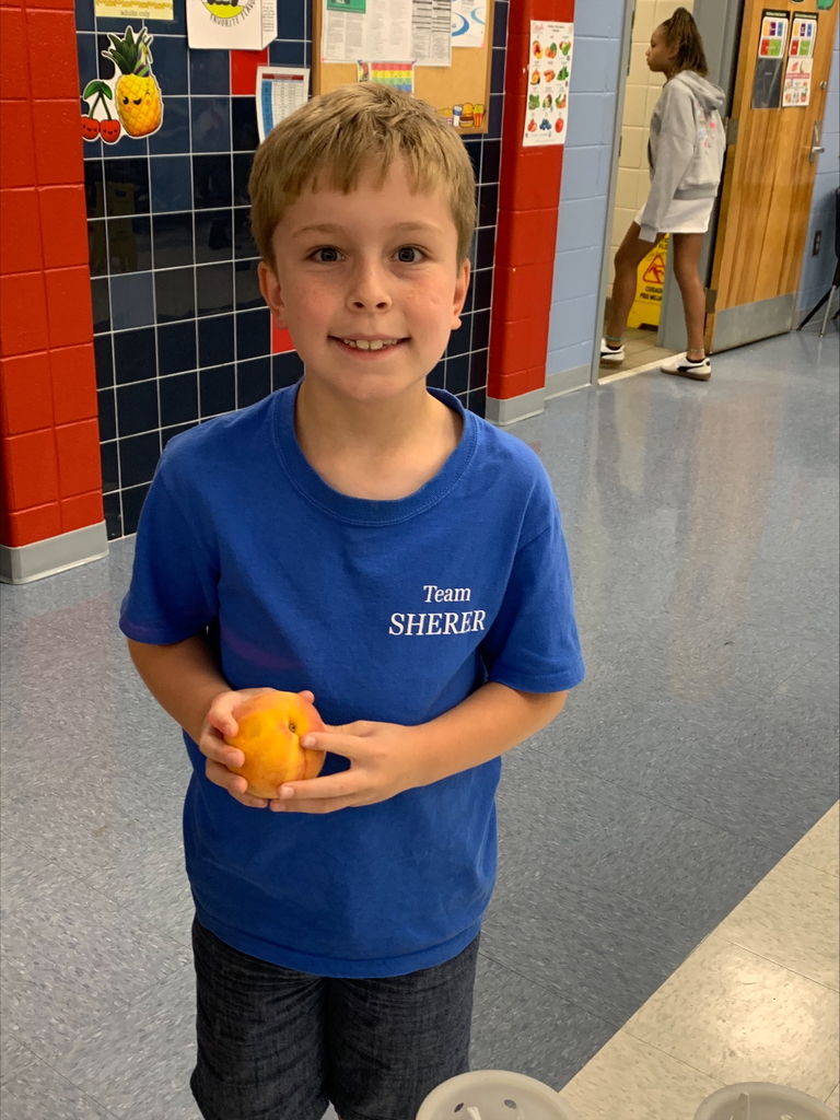 Student holding a peach.