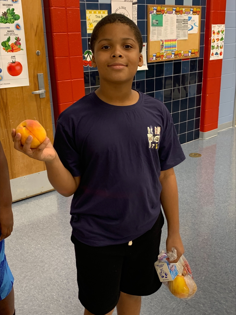 Student holding a peach.