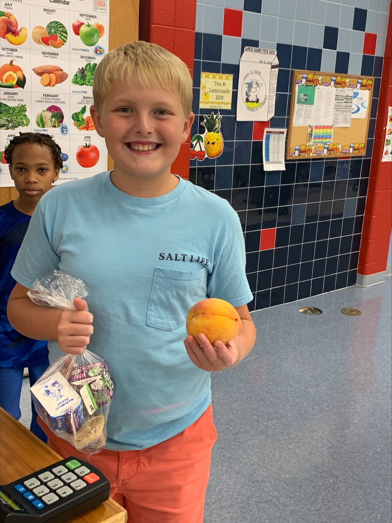 Student holding a peach.