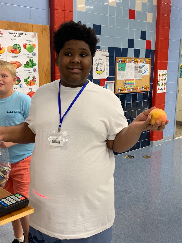 Student holding a peach.