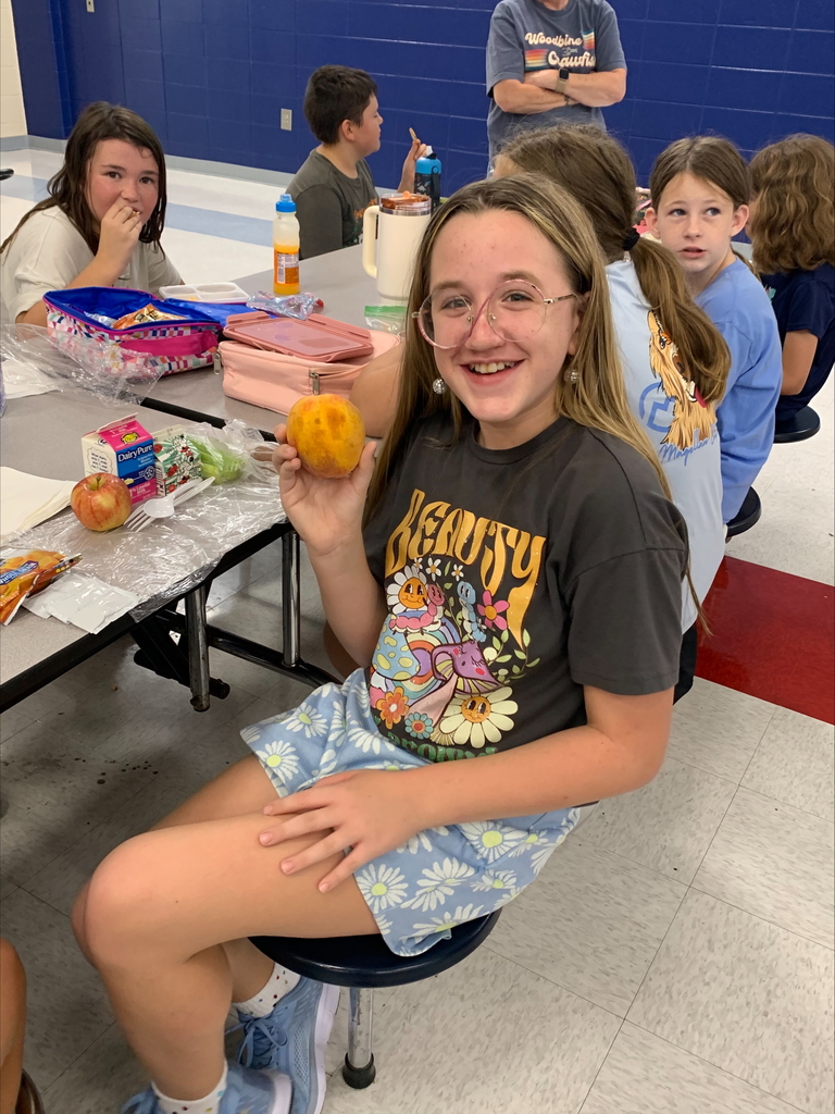 Student holding a peach.