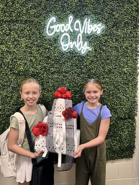 Students standing by the wedding cakes they built