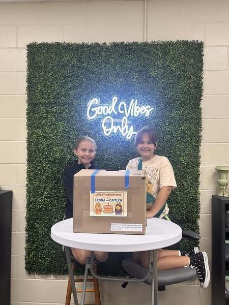 Students standing by the wedding cakes they built