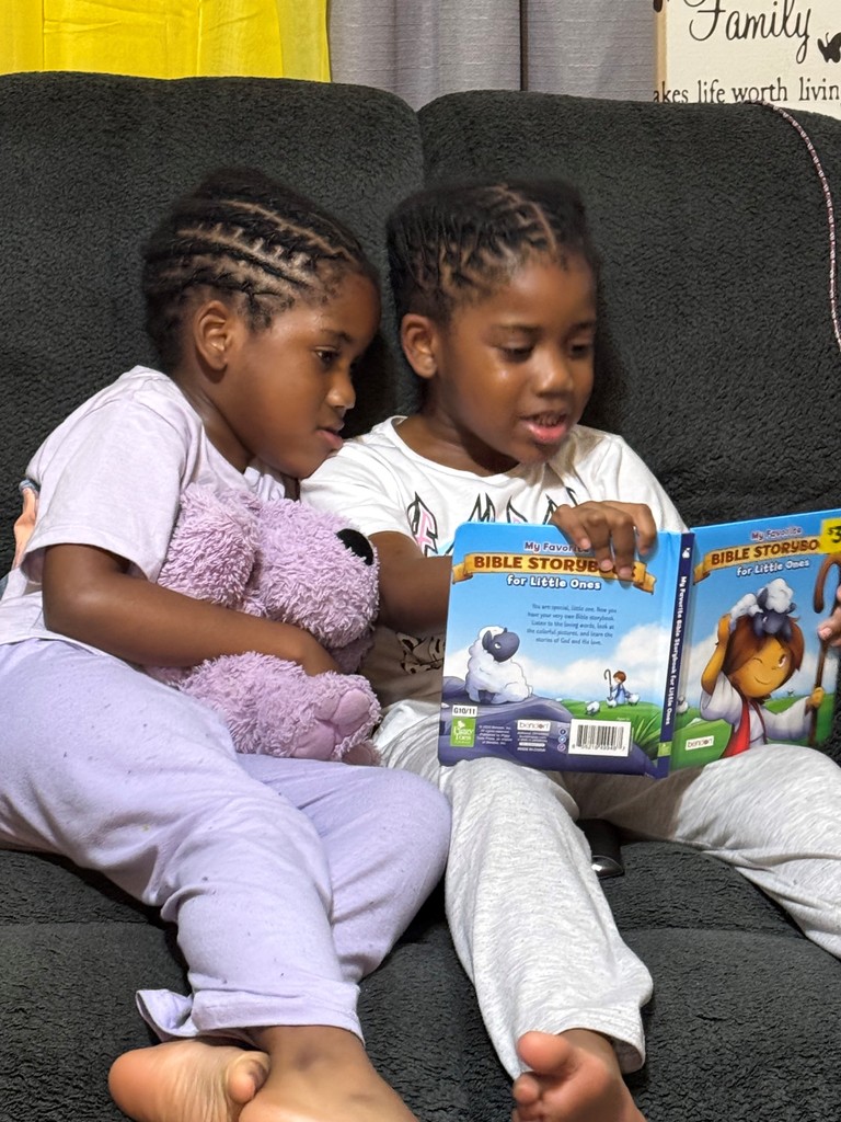 Girls reading to stuffed animal
