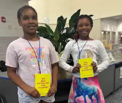 Students holding dictionaries.