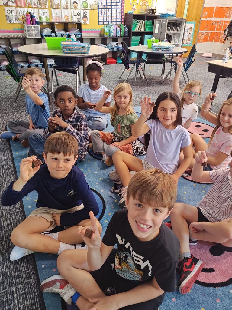 students holding chocolate bars and smiling