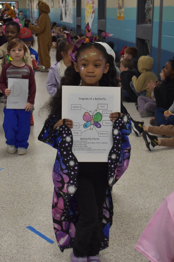 girl walking in parade dressed up as a butterfly