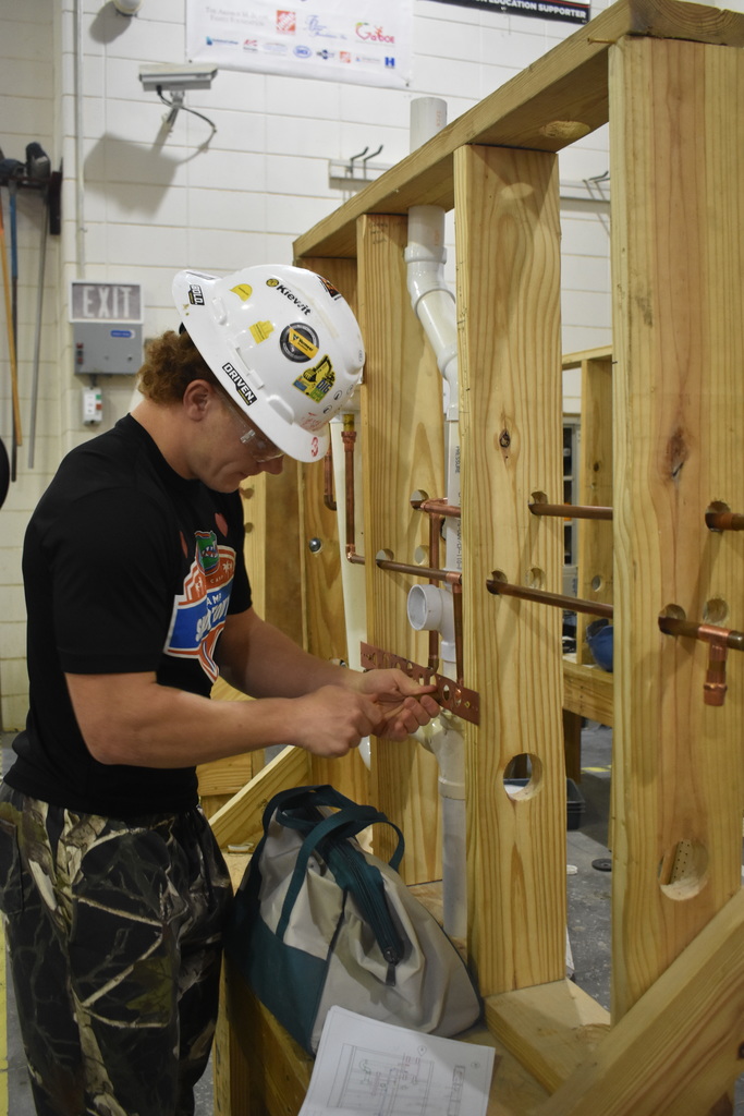 student working with wood and walls