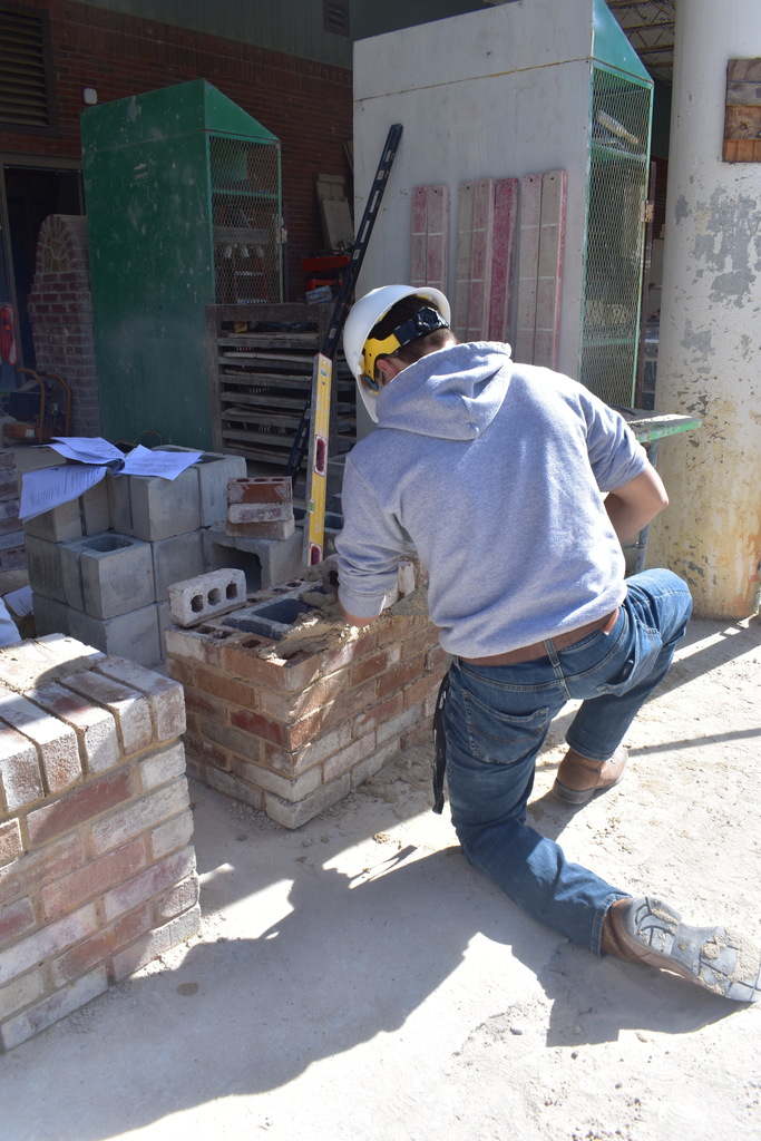 student doing grout and brick work