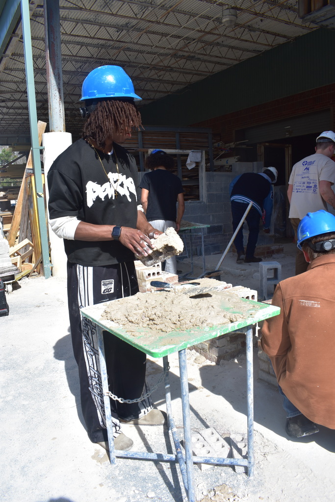 student doing grout and brick work