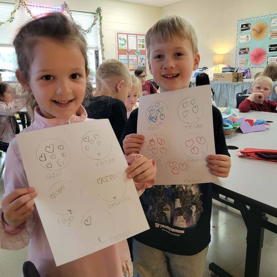 students holding up their assignment