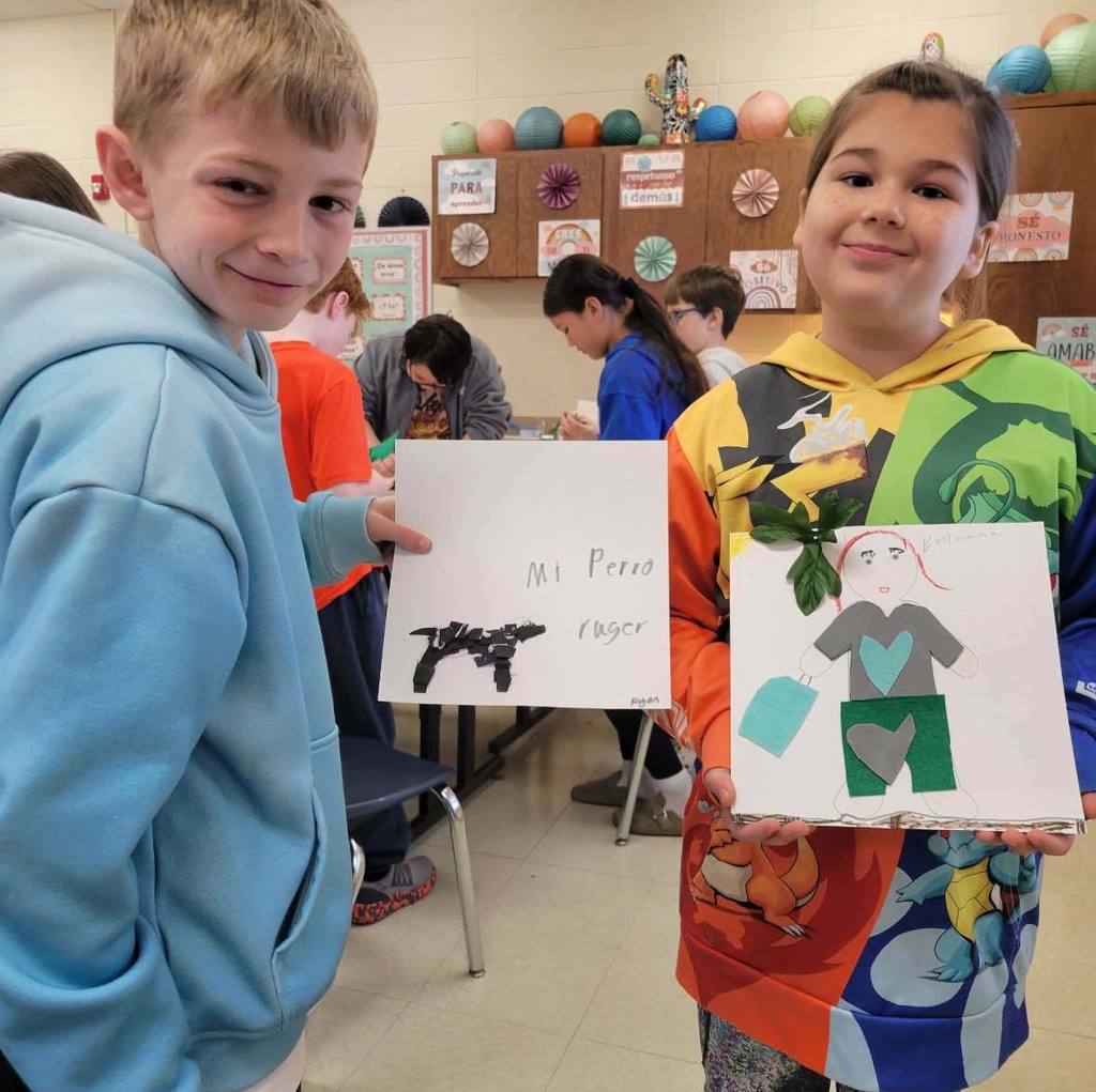 students holding up their assignment