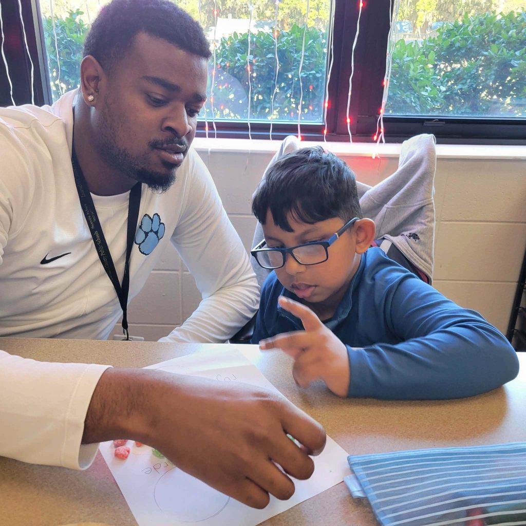 student getting guidance from teacher on assignment