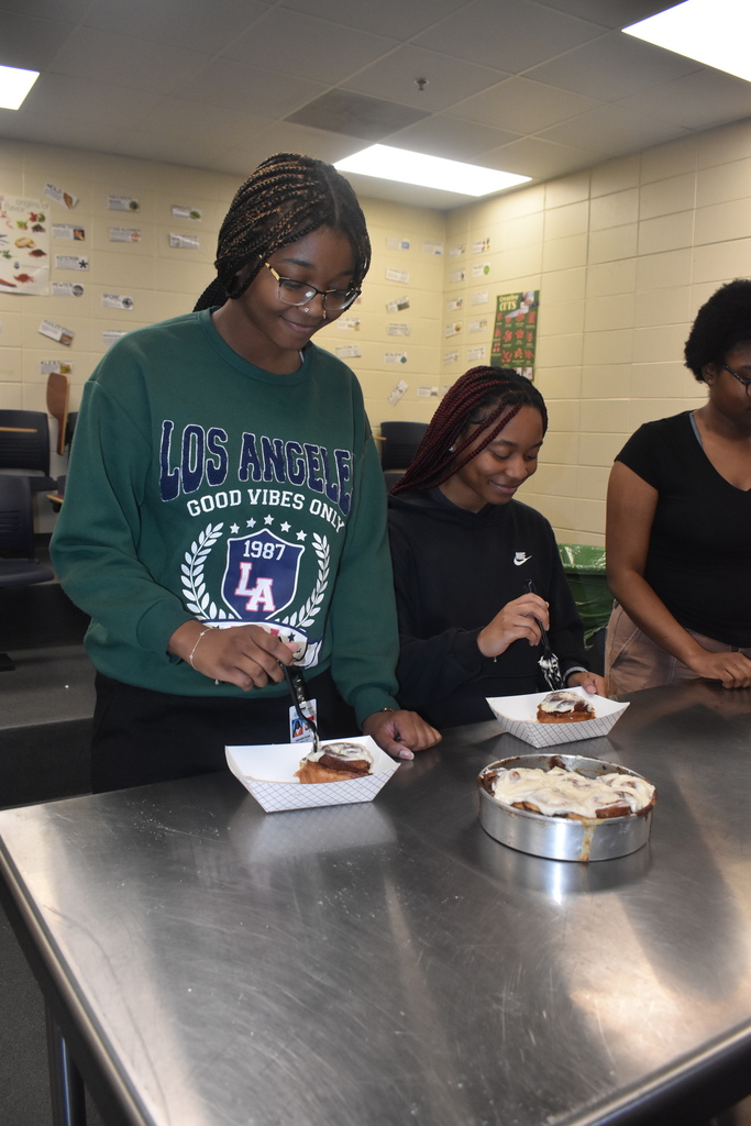 students eating the cinnamon rolls they made 