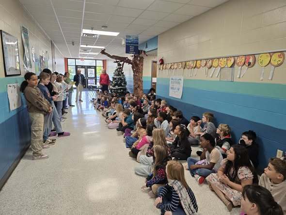 students reading poem to other students in hallway