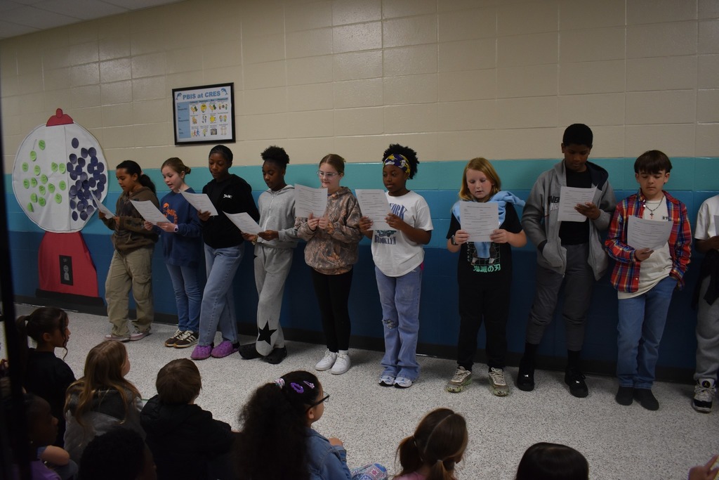 students reading poem to other students in hallway