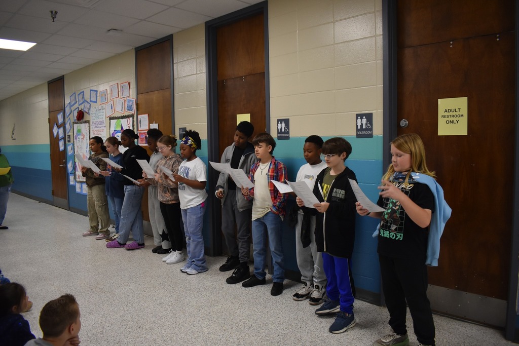 students reading poem to other students in hallway