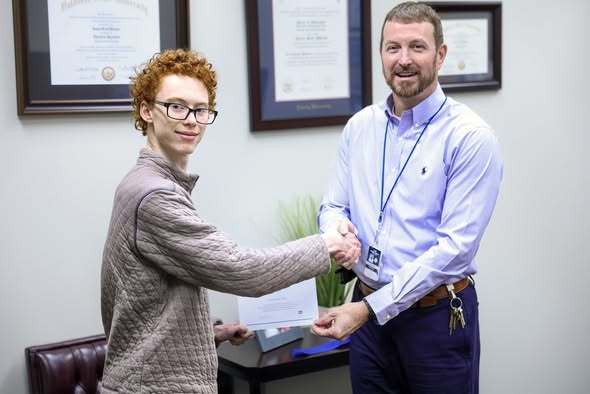 alexander and cchs principal shaking hands