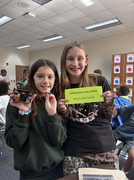 students showing their LEGO prompt and what they created