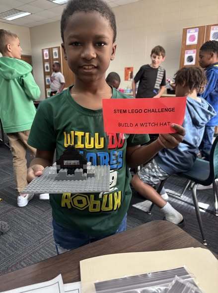 students showing their LEGO prompt and what they created