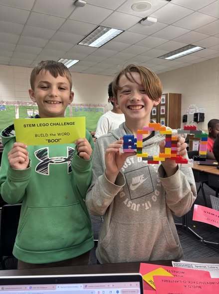 students showing their LEGO prompt and what they created