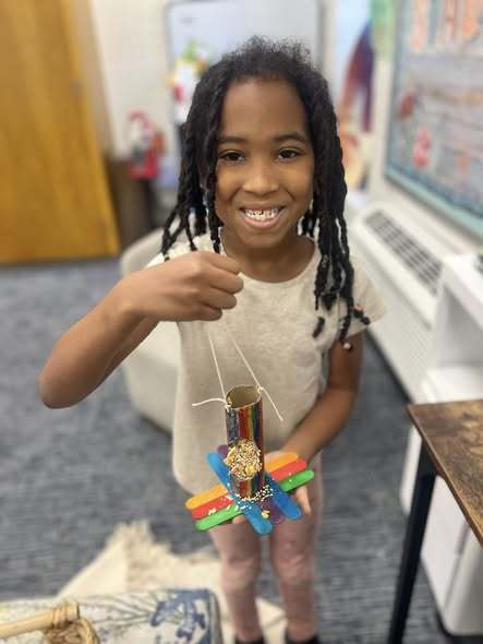 student holding up project