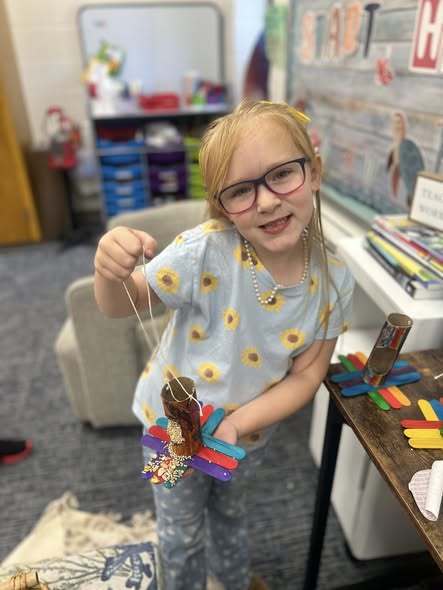 student holding up project