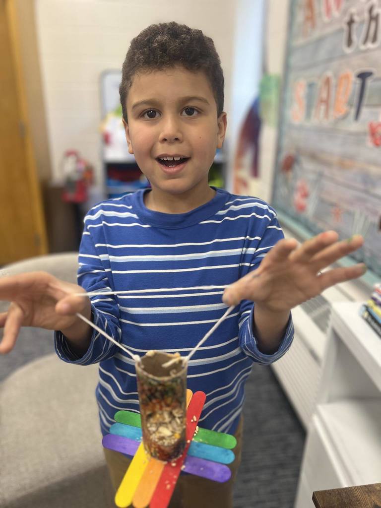 student holding up project