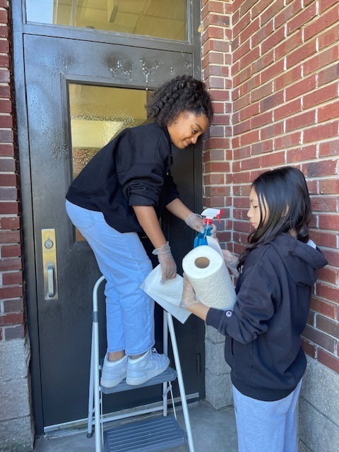 students cleaning door