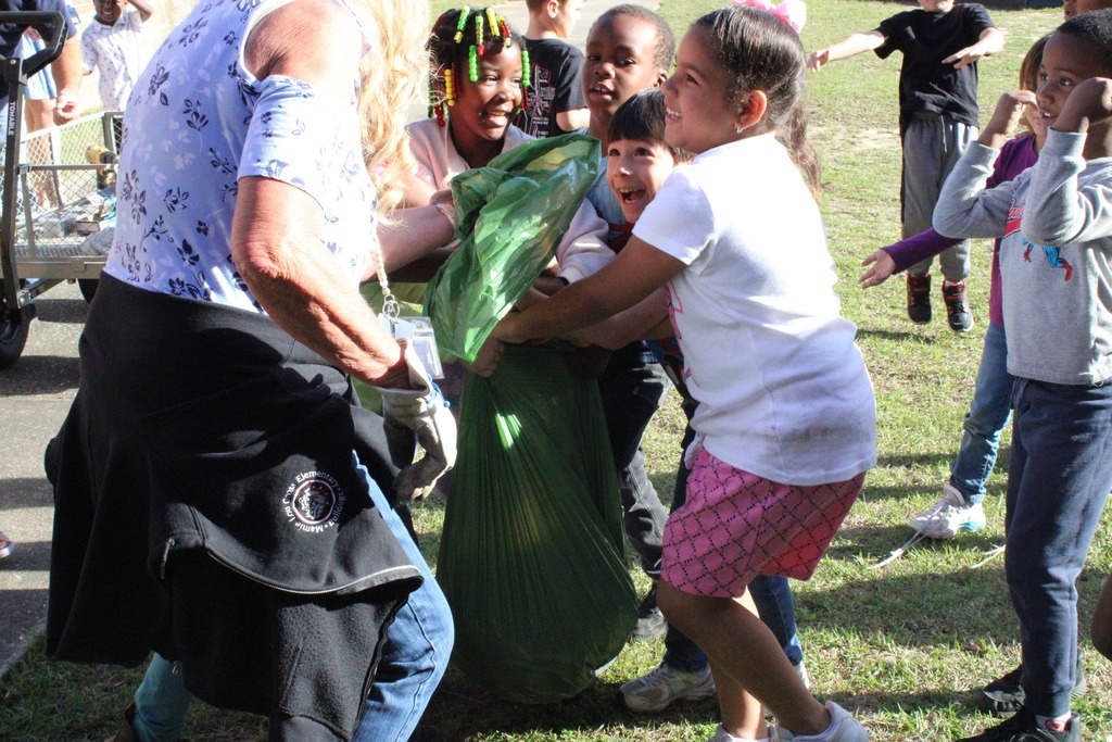 students holding the bag of weeds pulled