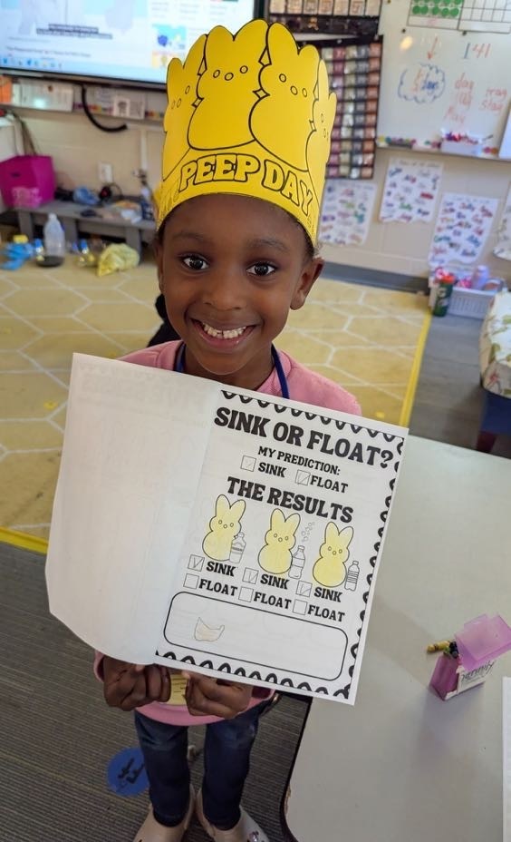 student showing off their assignment