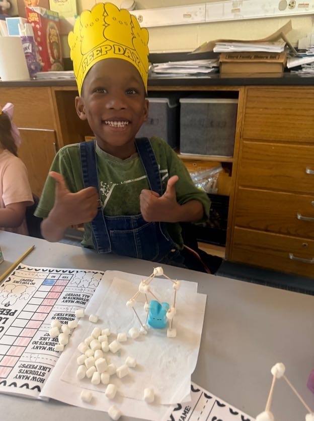 student smiling with his assignment