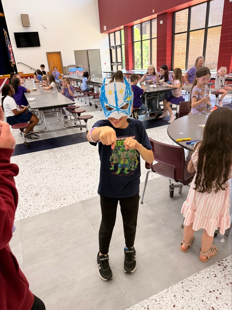 A group of elementary school students at David L. Rainer Elementary celebrate Purple Up Day. Students are wearing purple and participating in activities such as eating pizza and ice cream, getting their faces painted, and enjoying time together. The event honors military children during the Month of the Military Child.