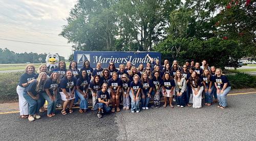 SES staff pose in front of Mariners Landing sign