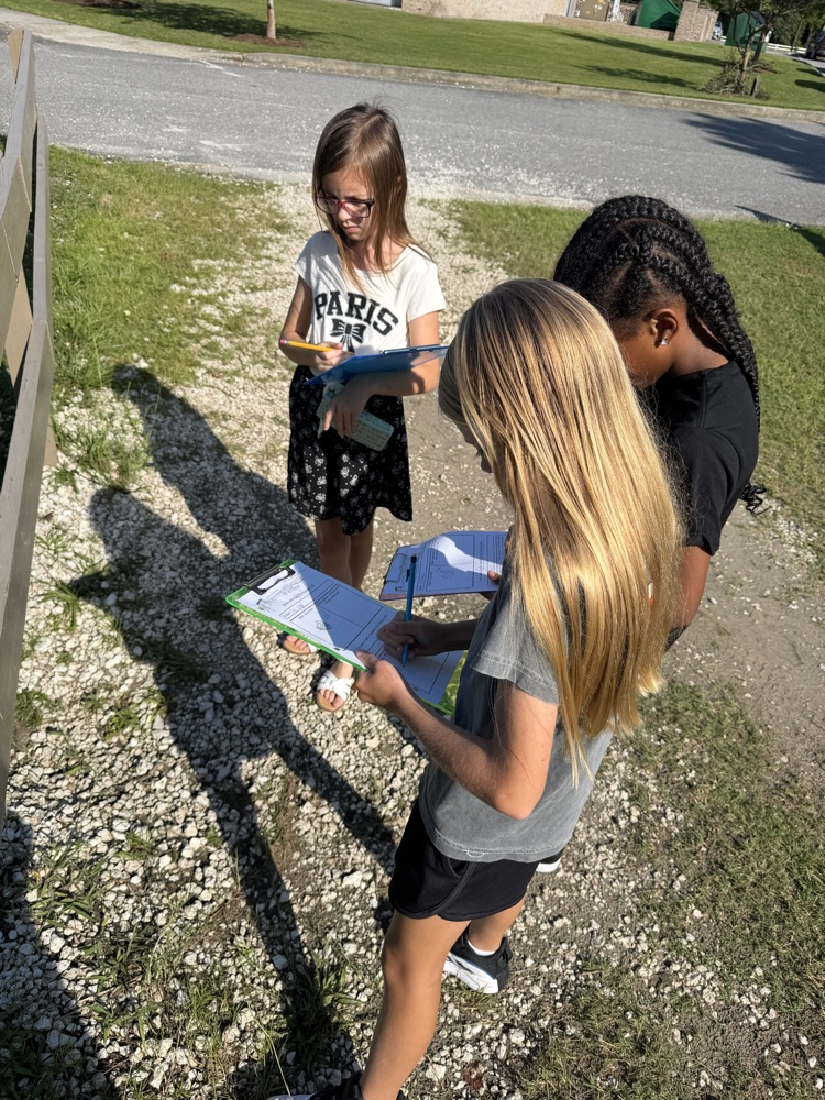 girls writing on clipboards