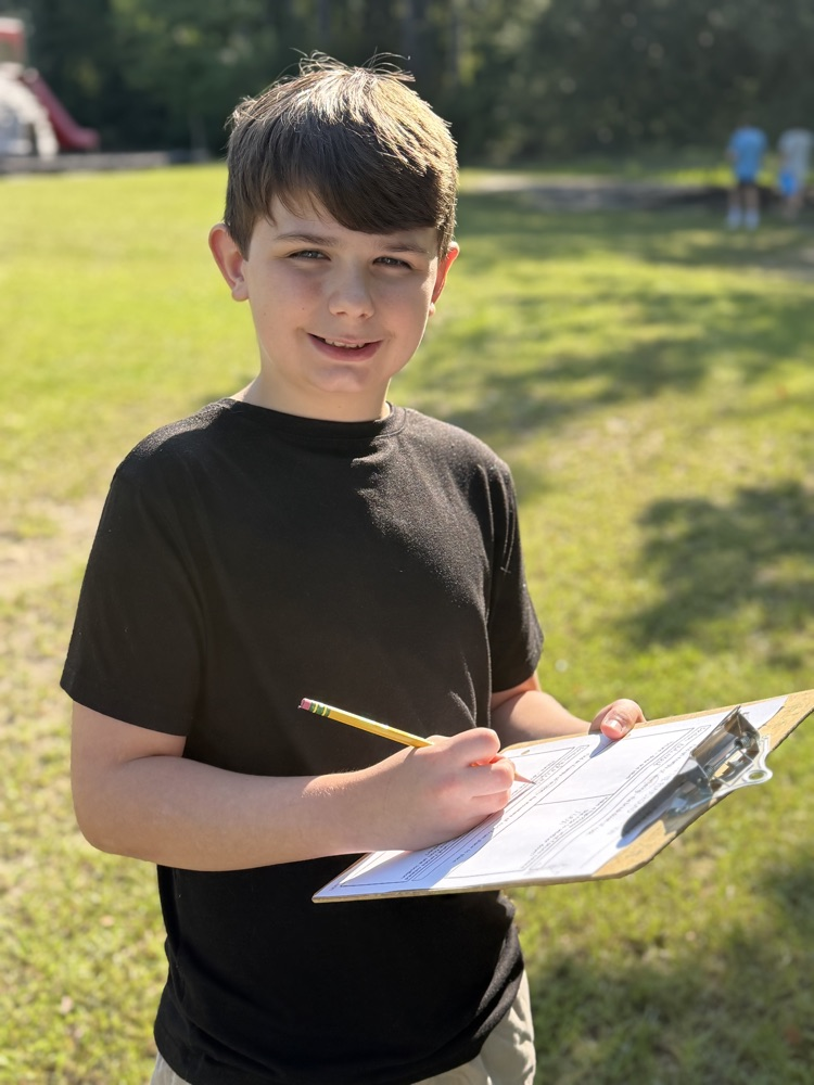 student smiling with clipboard