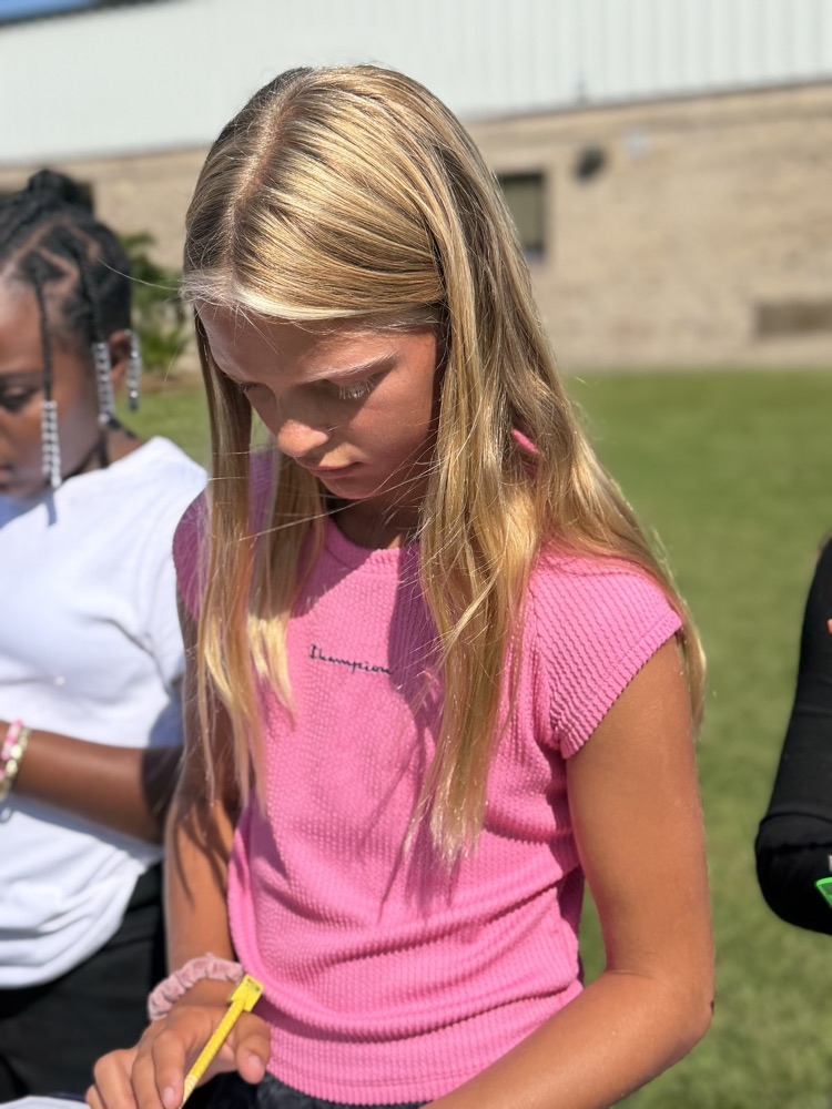 student writing on clipboard