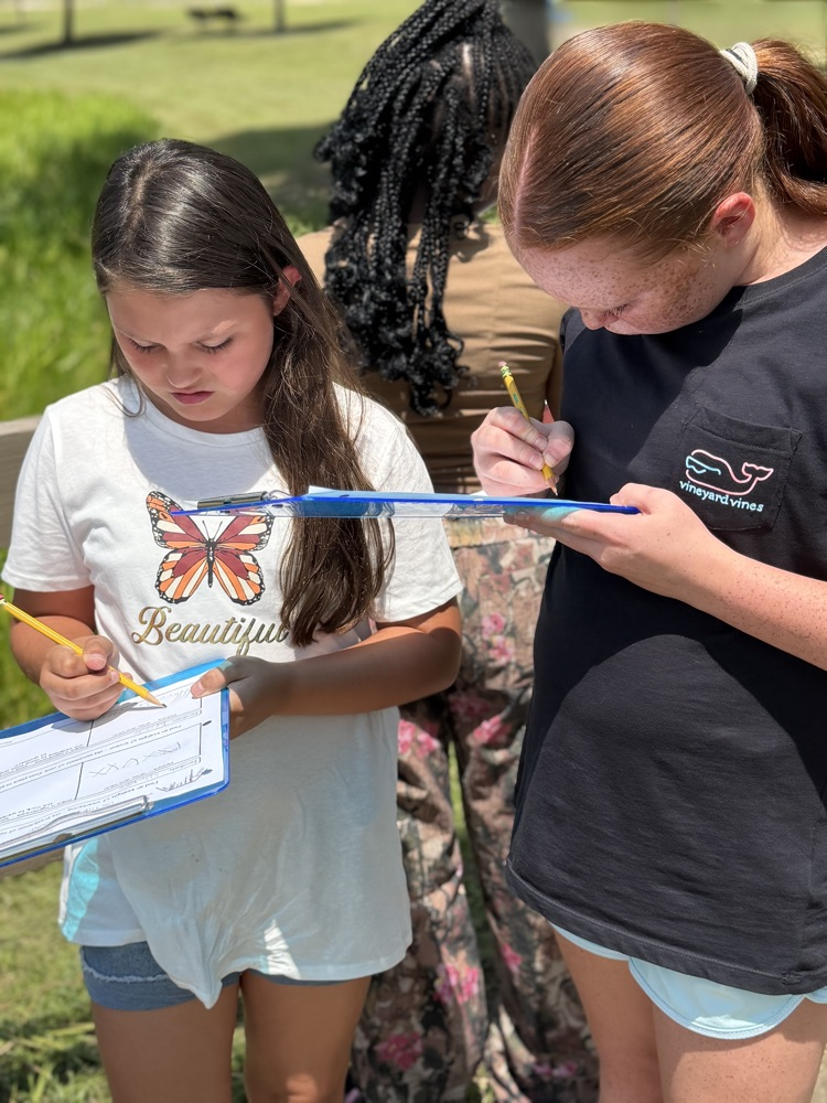 students writing on clipboards