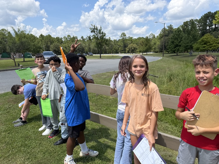 students smiling while working outside