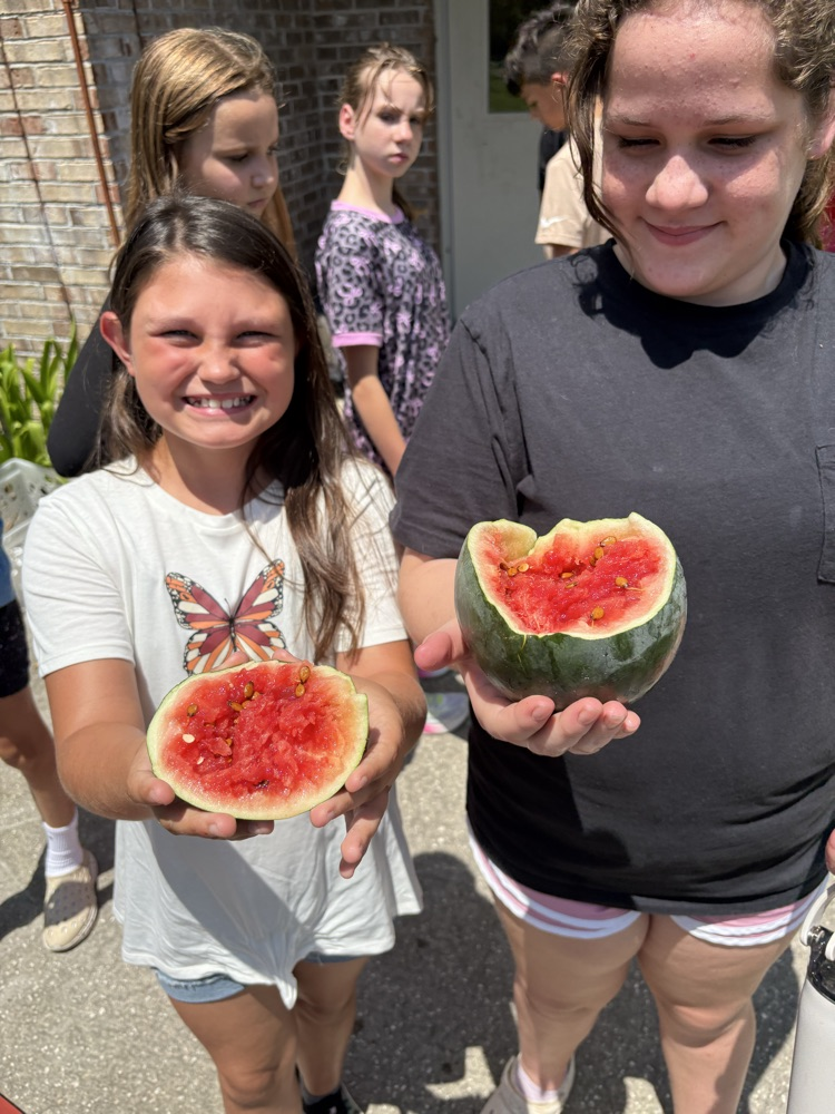girls holding watermelon from the garden