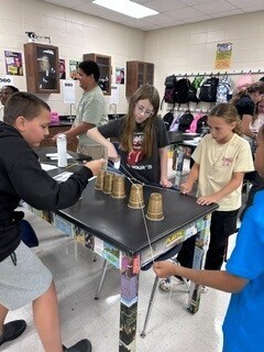 Students cooperatively working to stack cups