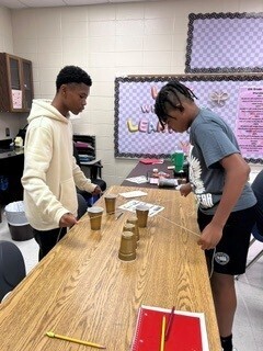 Students cooperatively working to stack cups