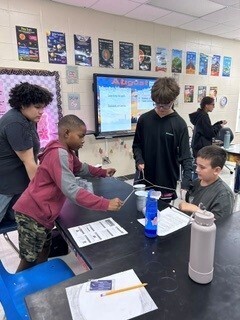 Students cooperatively working to stack cups