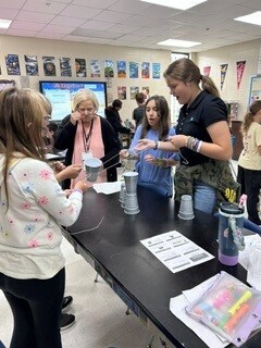 Students cooperatively working to stack cups