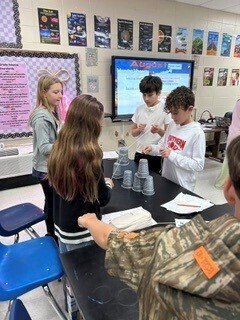 Students cooperatively working to stack cups